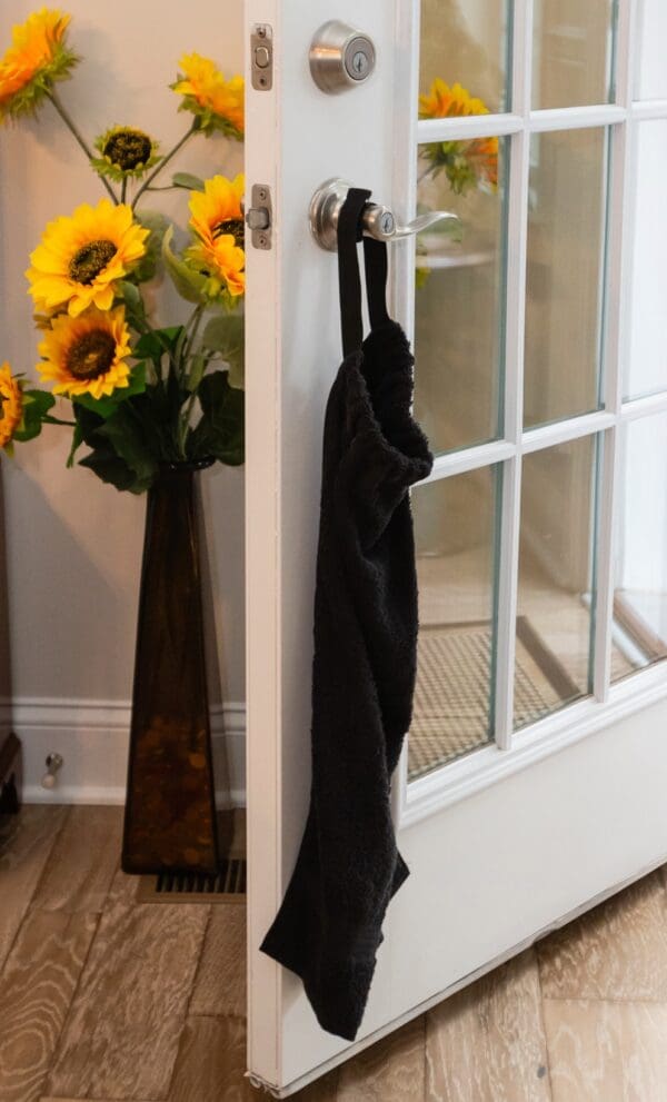 A black umbrella hanging on the side of a door.